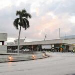 Power Grab Hits Palm Beach Airport Airport terminal exterior with palm tree at dusk