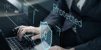 Person typing on laptop with digital security shield overlay