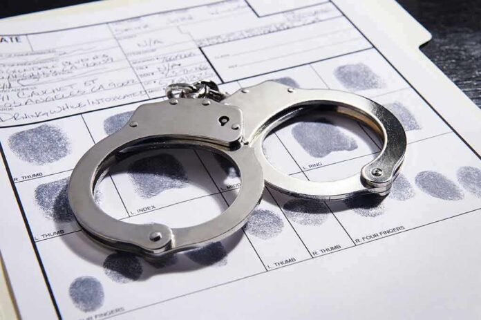 shutterstock_608376650 Handcuffs on a fingerprint record form