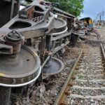 Overturned train cars beside railway tracks