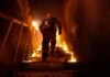 Firefighter climbing burning stairwell