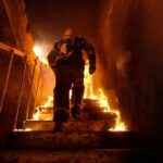 Firefighter climbing burning stairwell