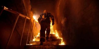 Firefighter climbing burning stairwell