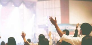 Audience raising hands at indoor event
