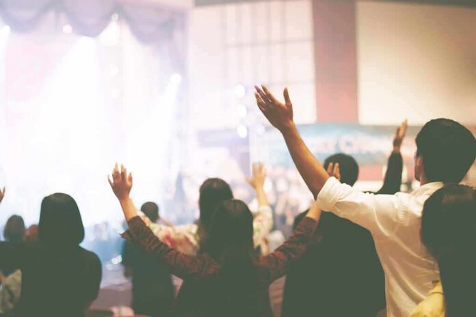 Audience raising hands at indoor event