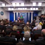 Rogue AI Sparks DC Meltdown Press secretary at podium addressing reporters in briefing room
