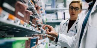 Pharmacists selecting medication from pharmacy shelves