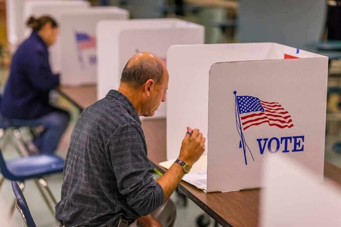 shutterstock_1046168680 Voter fills out ballot at a polling booth