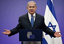Israel Finds UNLIKELY Allies Across Europe man in suit speaking at a podium with Israeli flag