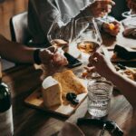 Ozempic Is SHRINKING America’s Dinner Plate Hands toasting wine glasses over a cheese board