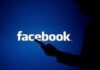 Facebook WHISTLEBLOWER Issues Dire Warning silhouette holding a smartphone in front of Facebook logo