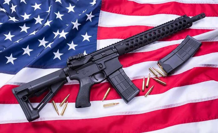 shutterstock_1086231848 AR-style rifle on American flag with magazines and bullets