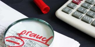 Magnifying glass over financial spreadsheet with red marker and calculator