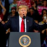 Trump Gives WNBA Star SHOUTOUT at Rally Donald Trump speaking at a rally podium with arms raised