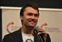 man speaking into a microphone on stage