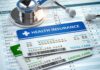 Health insurance cards on medical forms with stethoscope