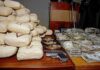 Seized packages, cash, and handguns on a table