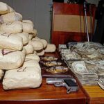 Trump Goes After Sinaloa CARTEL Cash Seized packages, cash, and handguns on a table