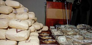 Seized packages, cash, and handguns on a table