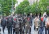 group of masked protesters walking through a city street