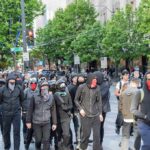 Teacher BLAMES Somali Parents for Troubled Kids group of masked protesters walking through a city street