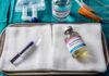Medical tray with syringe and pentobarbital vials on gauze