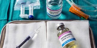 Medical tray with syringe and pentobarbital vials on gauze