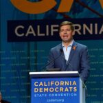 Eric Swalwell speaks at a podium during a California Democrats event