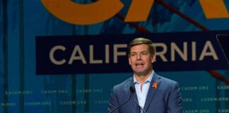 Eric Swalwell speaks at a podium during a California Democrats event