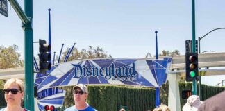 Crowd walking past a Disneyland Resort entrance sign