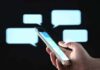 Parents Hit With Surprise TRANSGENDER Texts Hand holding smartphone with chat bubbles on dark background