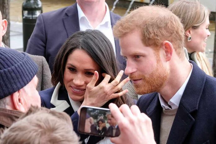 Prince Harry and Meghan, Duchess of Sussex greet people in a crowd