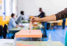 Hand casting ballot into a box at a polling station