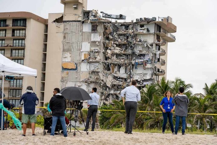 Partially collapsed beachfront apartment building with onlookers