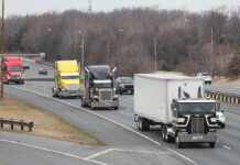 Convoy of semi trucks driving on a multi-lane highway