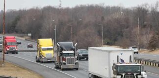 Convoy of semi trucks driving on a multi-lane highway