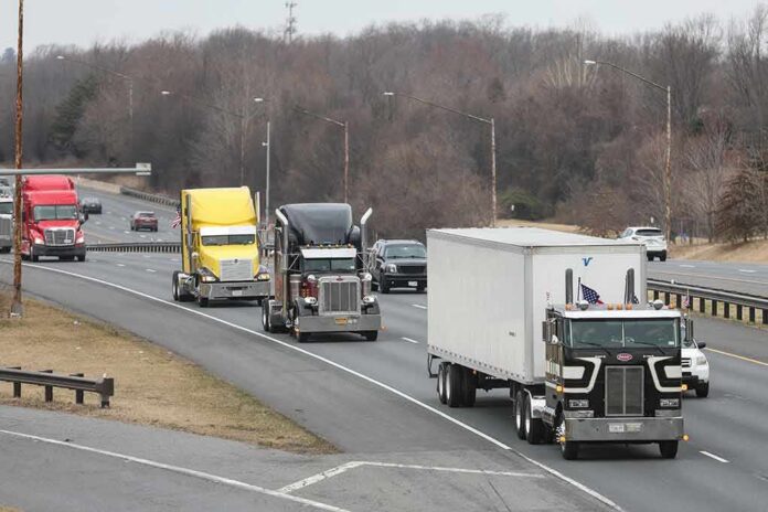 shutterstock_2132851557 Convoy of semi trucks driving on a multi-lane highway