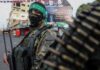 armed person in camouflage with face covering on a city street