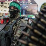 armed person in camouflage with face covering on a city street