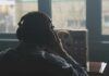 OpenAI Engineer Accused of BUGGING Executives Person wearing headphones listening to a reel-to-reel tape recorder