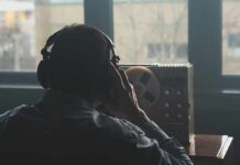 OpenAI Engineer Accused of BUGGING Executives Person wearing headphones listening to a reel-to-reel tape recorder