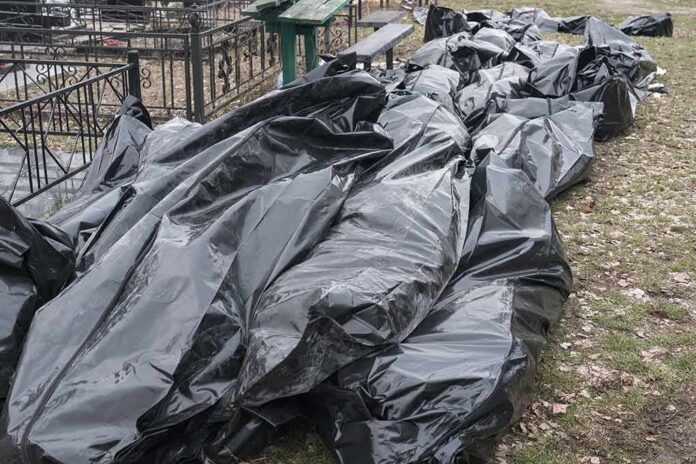 shutterstock_2203463897 Black plastic bags piled outdoors near metal fencing