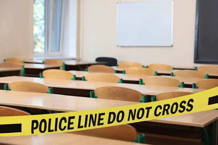 shutterstock_2344759813-1 Empty classroom with police tape across desks