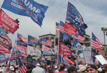 Why Trump Is Campaigning in DEEP-RED Mississippi Crowd at political rally with many American and campaign flags