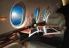 private jet cabin with leather seat, champagne and magazine on table