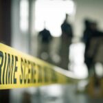 Crime scene tape with investigators in the background