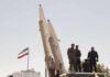 Iran’s NUCLEAR Taboo Is Breaking Soldiers stand beside large missiles at an outdoor display