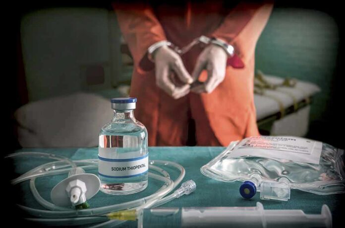 Medical vials and IV lines on a table with a handcuffed person in the background